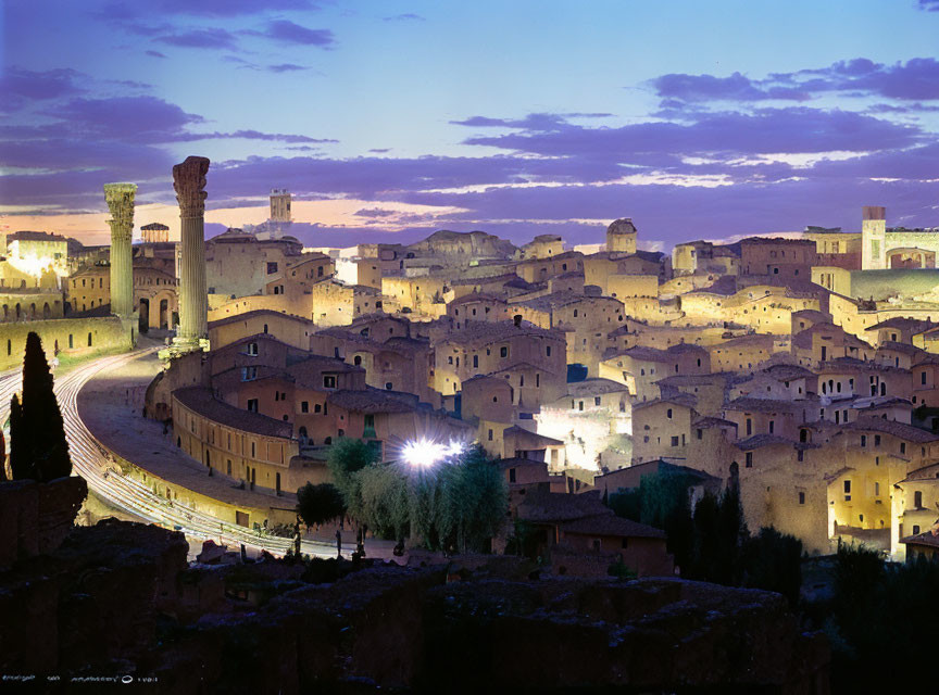 Historic cityscape with ancient ruins and illuminated streets at twilight