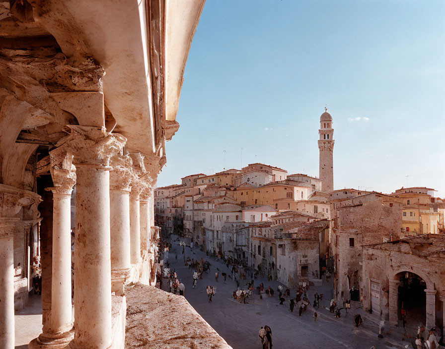 Historic town square with bell tower and elegant columns beneath clear blue sky