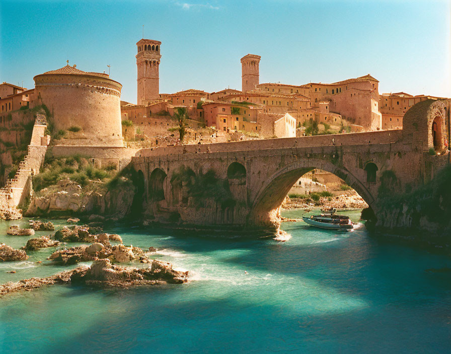 Stone bridge with arches over river to fortified town against clear sky