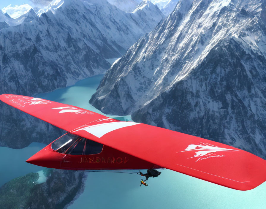 Red glider flying over turquoise river in snowy mountains