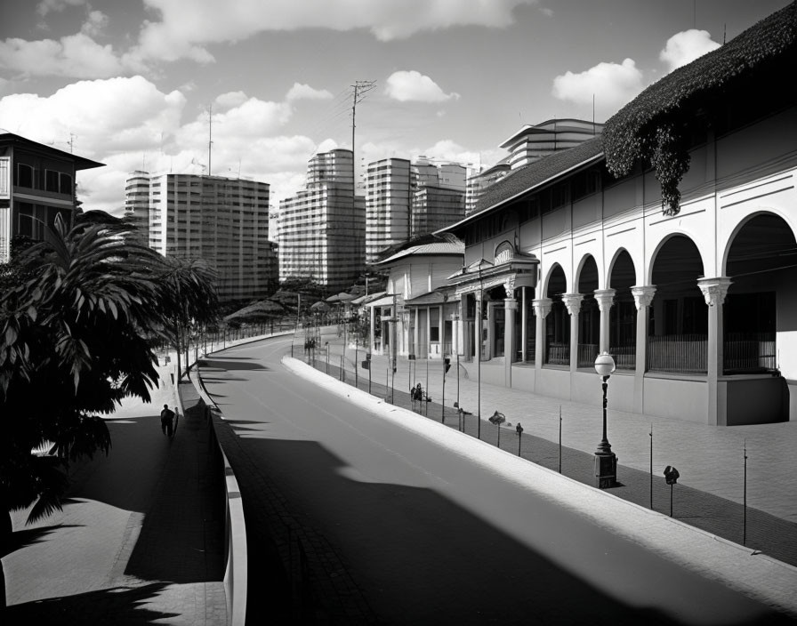 Tranquil urban street with traditional and modern buildings, street lamps, and lone pedestrian