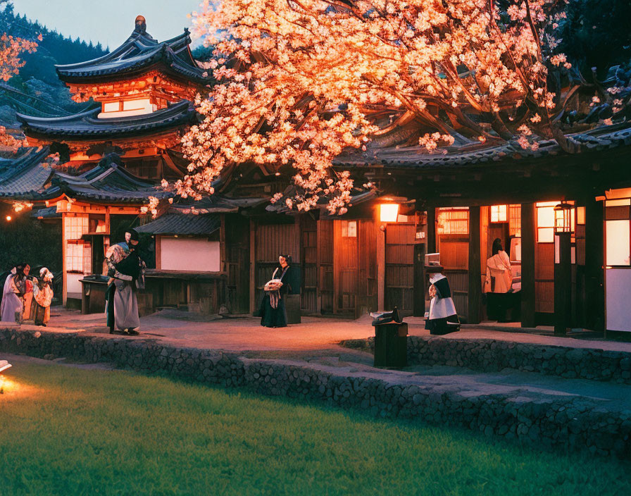 Traditional Japanese attire under cherry blossoms at night near historical building.