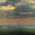 Vibrant sky over rolling green hills with celestial bodies