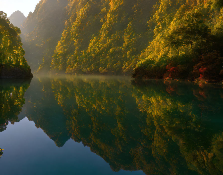 Autumn sunrise over serene lake and forested hills