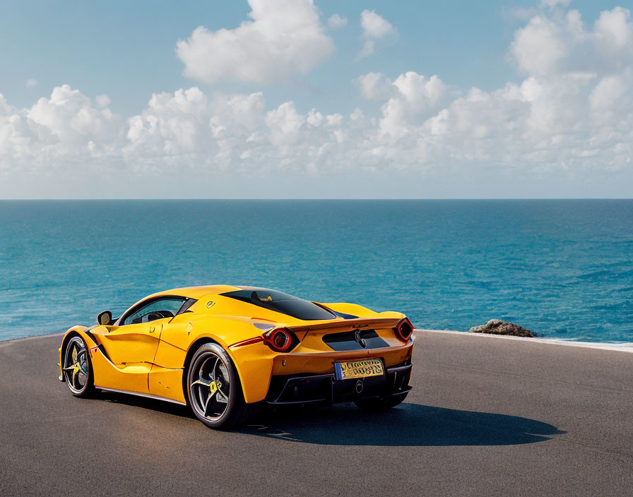 Yellow Sports Car Parked on Coastal Road with Blue Sky & Ocean