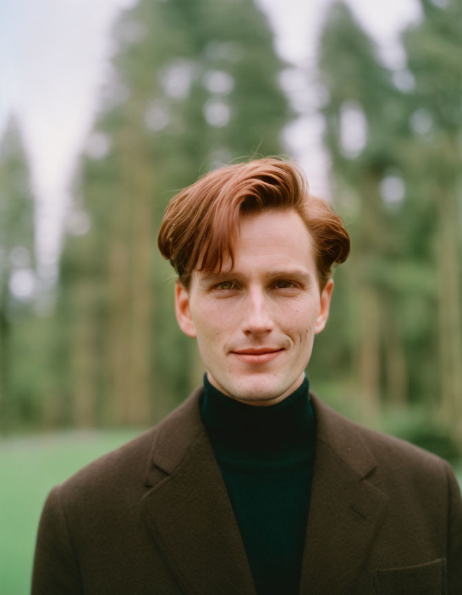 Man with Auburn Hair in Brown Jacket and Black Turtleneck Smiling Outdoors