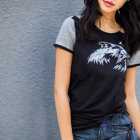 Person in Black Wolf Graphic T-shirt and Denim Jeans on Grey Wall