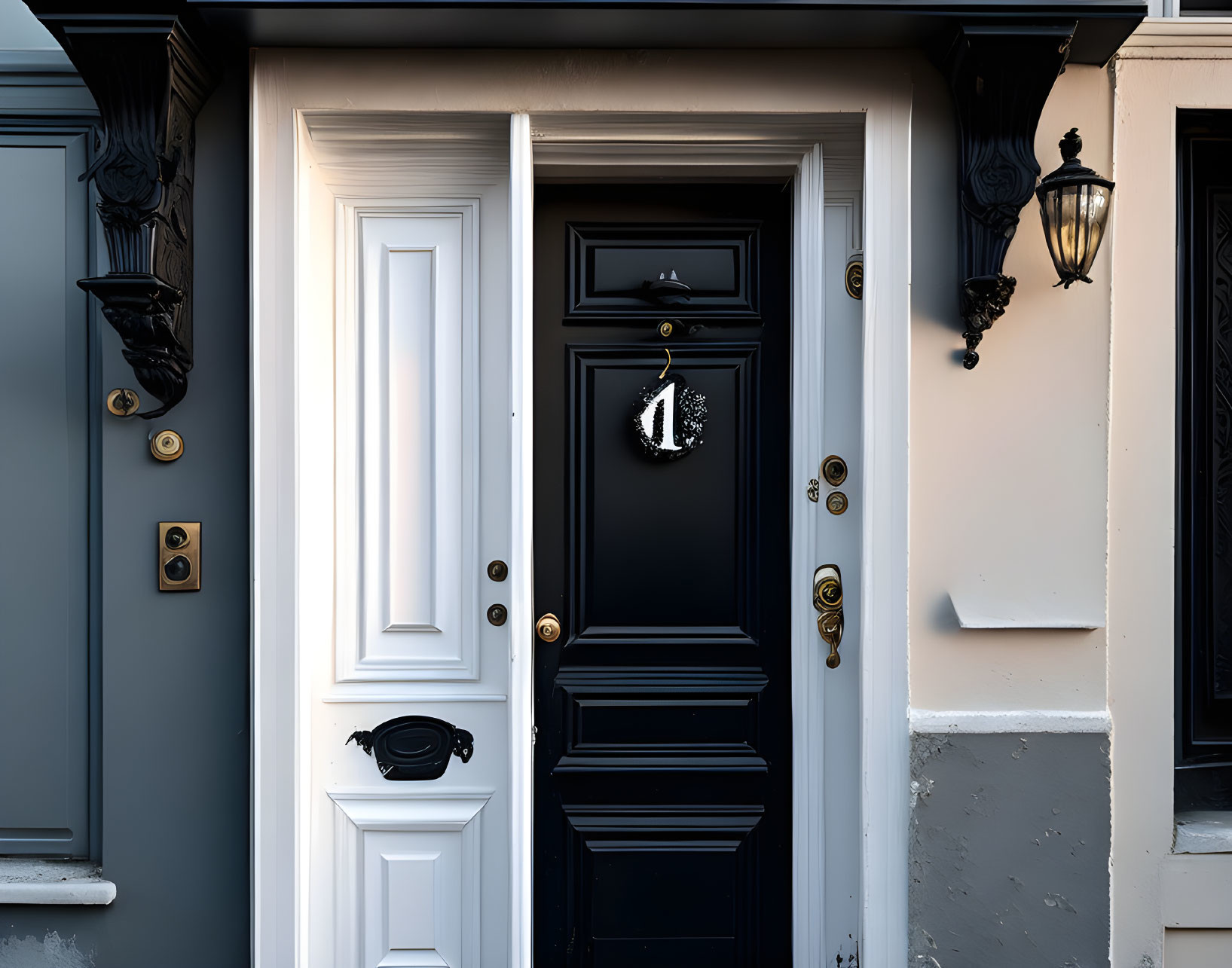 Stylish black front door with brass fixtures and number 1, framed by dark gray walls and