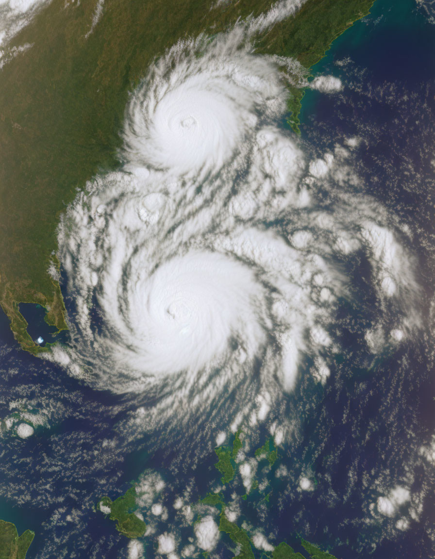 Twin hurricanes with spiral bands nearing landmass: satellite view