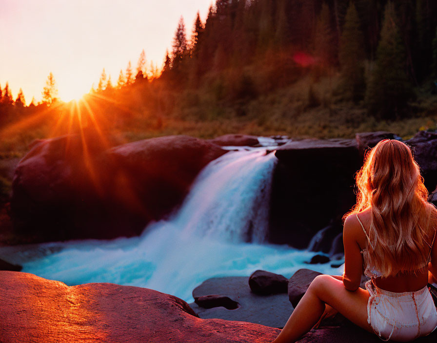 Woman Sitting on Rock by Waterfall at Sunset in Forest