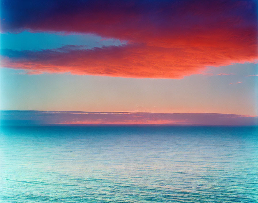 Vibrant Blue, Red, and Purple Gradient Sunset or Sunrise Over Tranquil Horizon