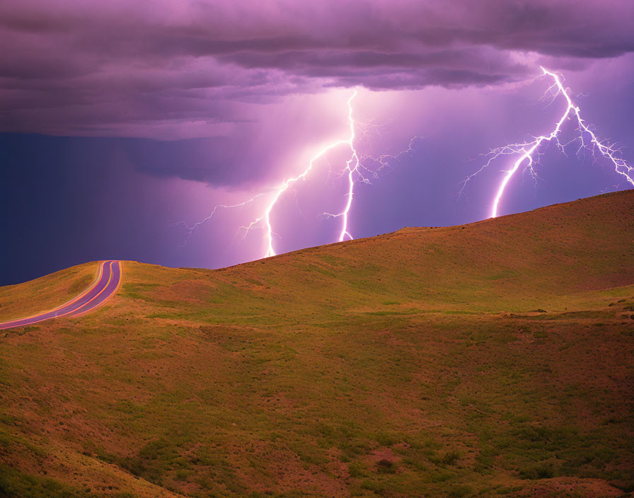 Scenic image of winding road on grassy hill under dramatic sky