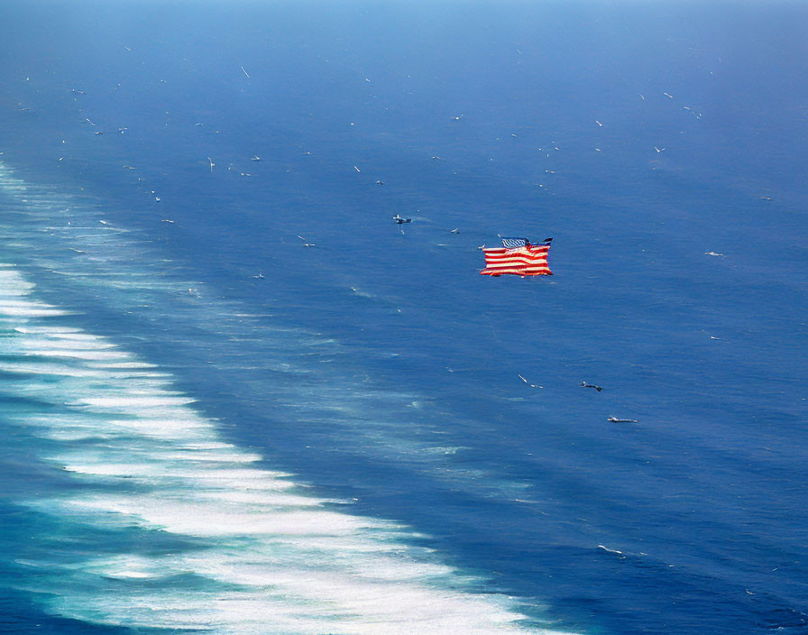 Helicopter with American flag over ocean waves and seabirds