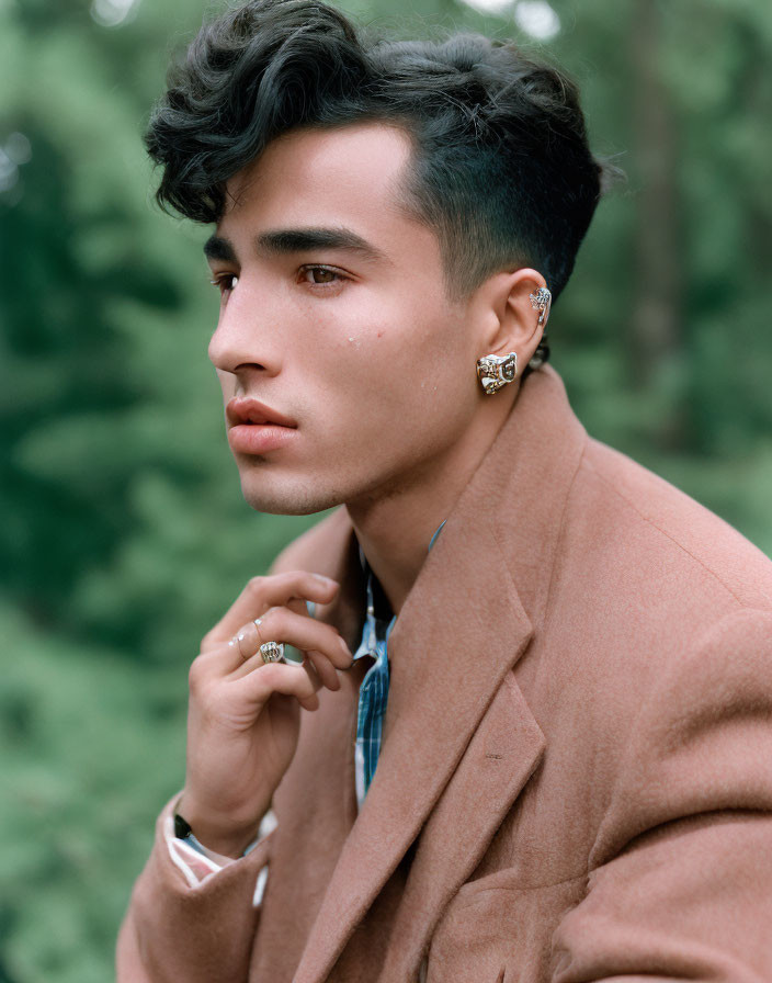 Stylized portrait of young man with wavy hair in profile wearing brown jacket