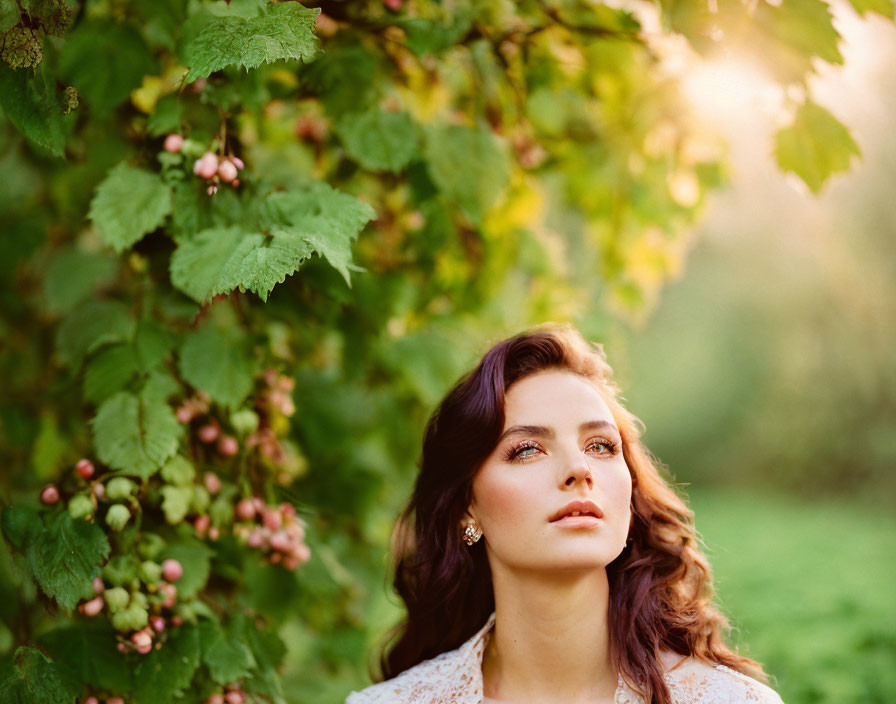 Serene woman surrounded by green foliage under soft sunlight