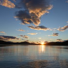 Vibrant surreal sunset reflected in water with celestial bodies and glowing clouds