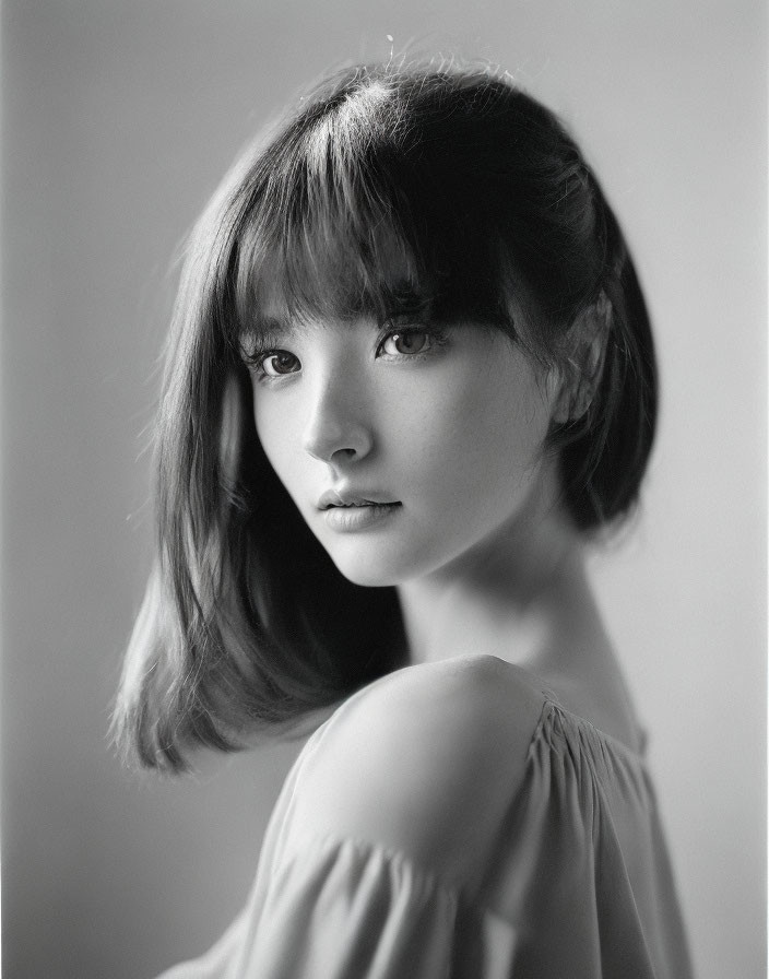 Monochrome portrait of young woman with bangs and shoulder-length hair