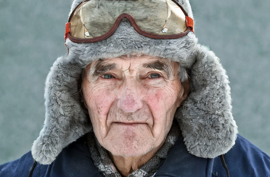 Elderly man in fur hat with goggles, exuding adventurous aura