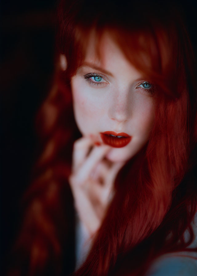 Striking red hair and blue eyes portrait against dark background