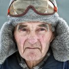 Elderly man in fur hat with goggles, exuding adventurous aura