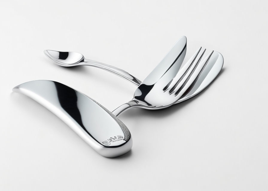 Shiny silverware set on white surface