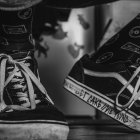 Monochrome person illustration with patterned high-top sneakers on wood planks