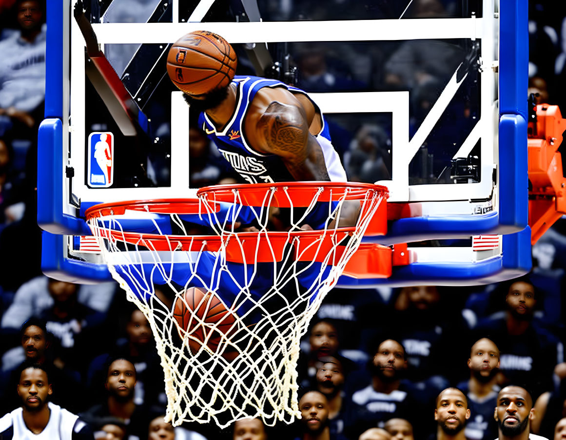 Basketball player in blue and white uniform scoring with spectators in background