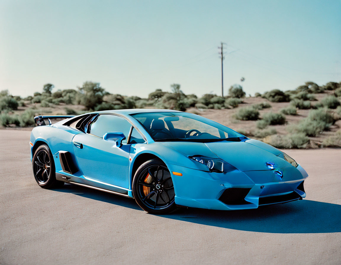 Blue Lamborghini Murcielago on asphalt with desert landscape and clear sky