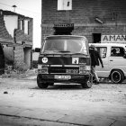 Monochrome photo: Three old cars on deserted dirt road