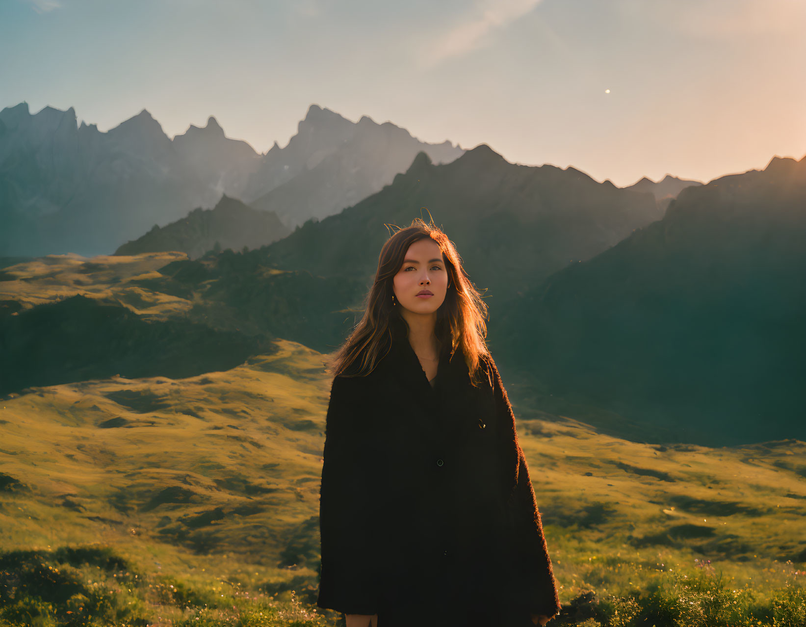 Person in Field at Sunset with Mountains Background