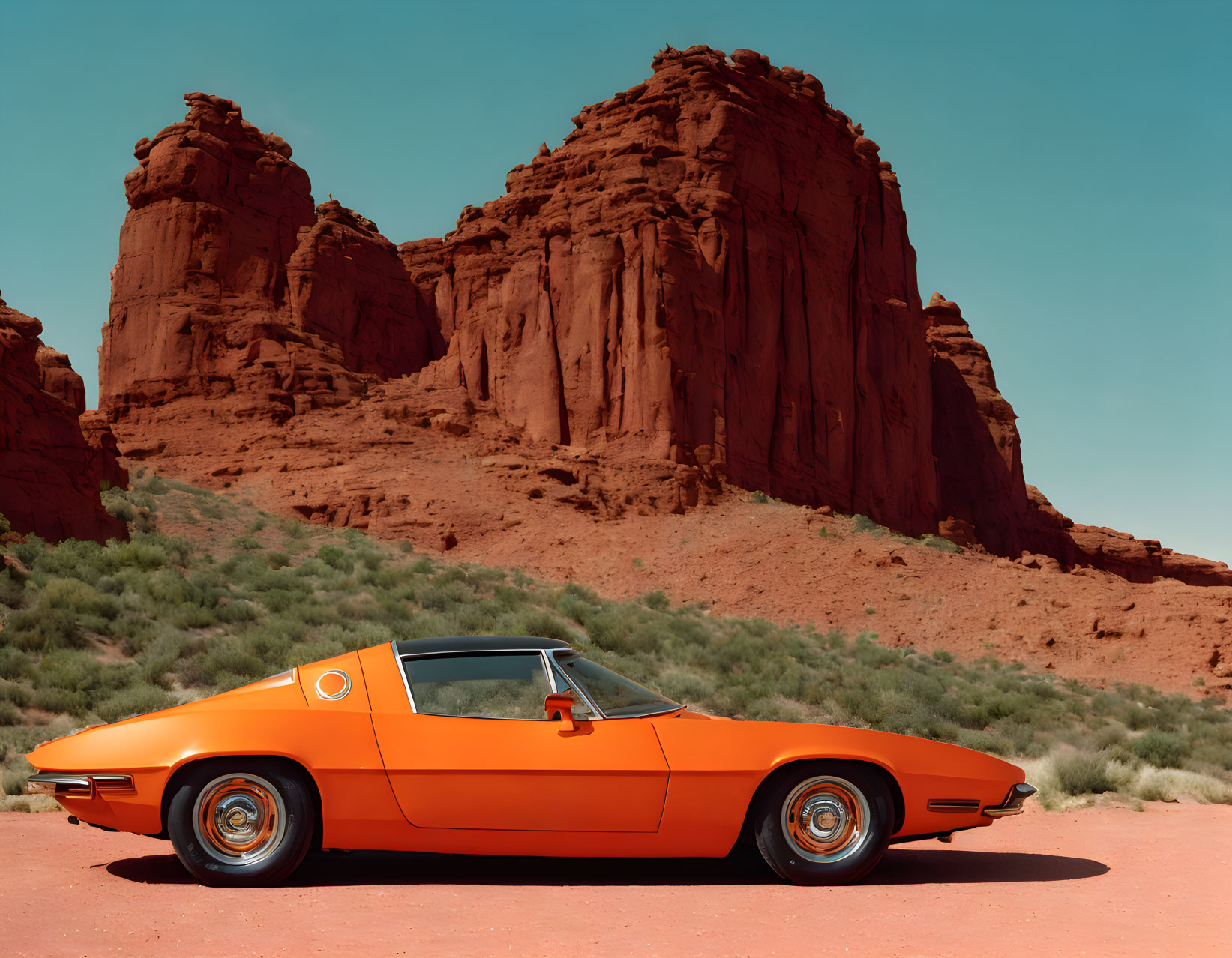 Vintage orange car parked by red cliffs under blue sky