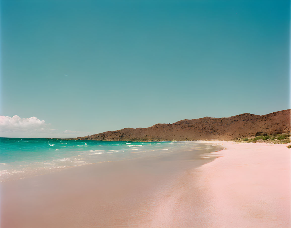 Tranquil beach scene with clear blue waters and mountainous backdrop