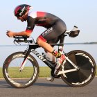 Geometric cyclist on bicycle with coastal background