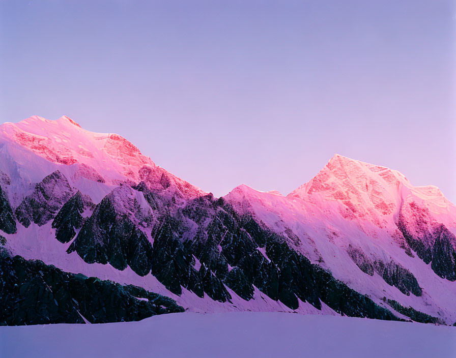 Majestic snow-covered mountains under pink and blue sky