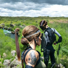 Two women in forest with rifles, tactical gear, alert