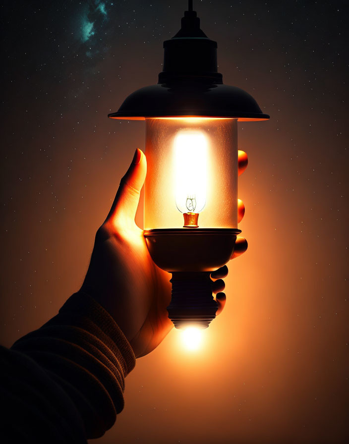 Silhouetted hand holding glowing lantern under starry sky