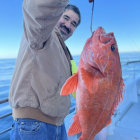 Men on boat with caught shark in blue ocean