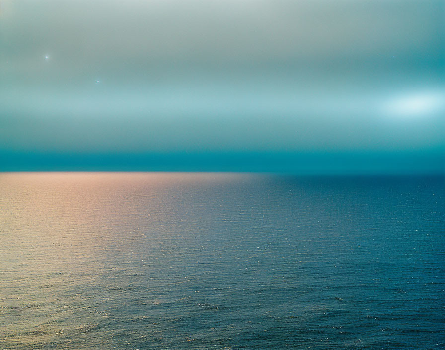 Twilight seascape with blue gradient and starlight reflections