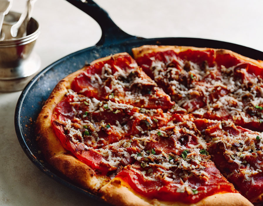 Pepperoni pizza with melted cheese and herbs in cast-iron skillet