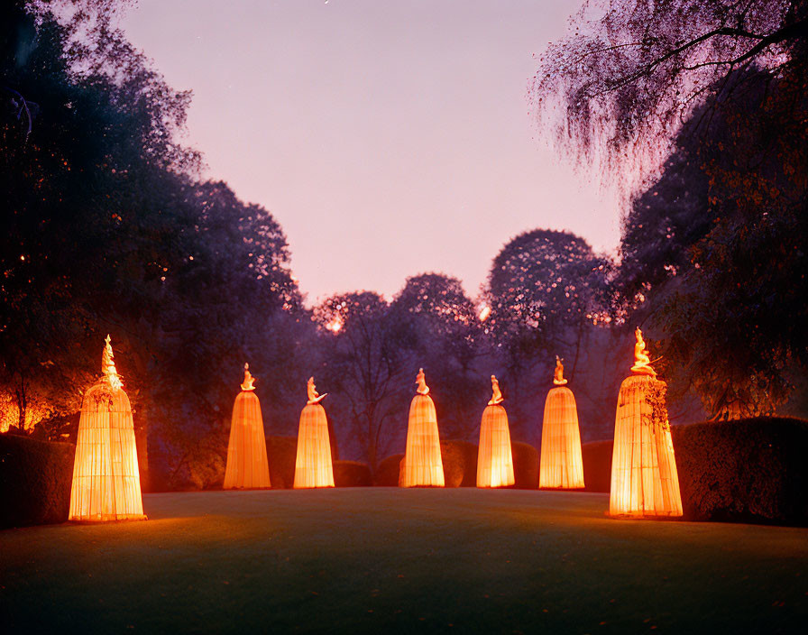 Cone-shaped lanterns in twilight setting with trees and grassy area