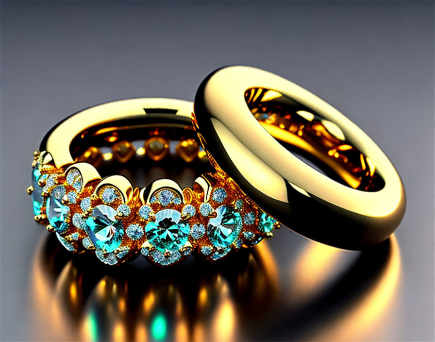 Golden rings with blue gemstones on reflective surface: one floral pattern, one smooth.