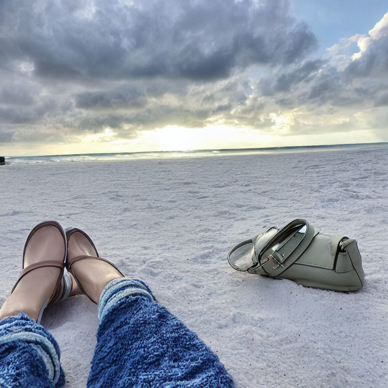 Beach scene with person in slippers and handbag at sunrise or sunset