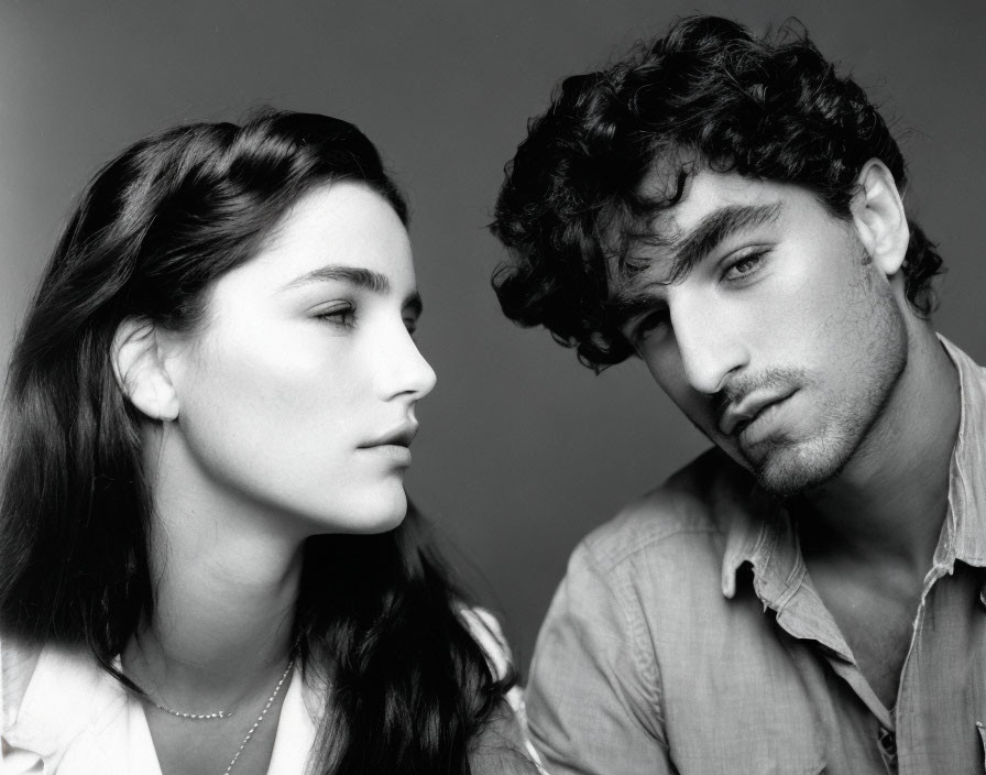Monochrome portrait of woman and man in close pose with serious expressions