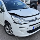 Futuristic white car with blue illuminated front grille on rocky terrain with mechanical structure