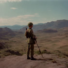 Man in suit on sandy hill overlooking vast desert landscape