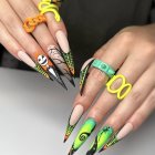 Shimmering holographic stiletto nails with yellow, green, and pink colors on black w