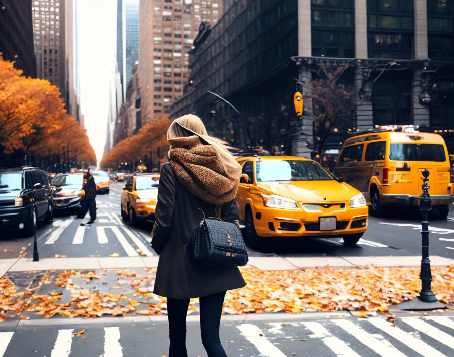 Woman in hijab at NYC crosswalk with fall foliage.