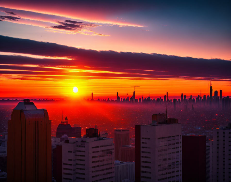 Vivid sunrise city skyline with orange-red hues and silhouetted skyscrapers