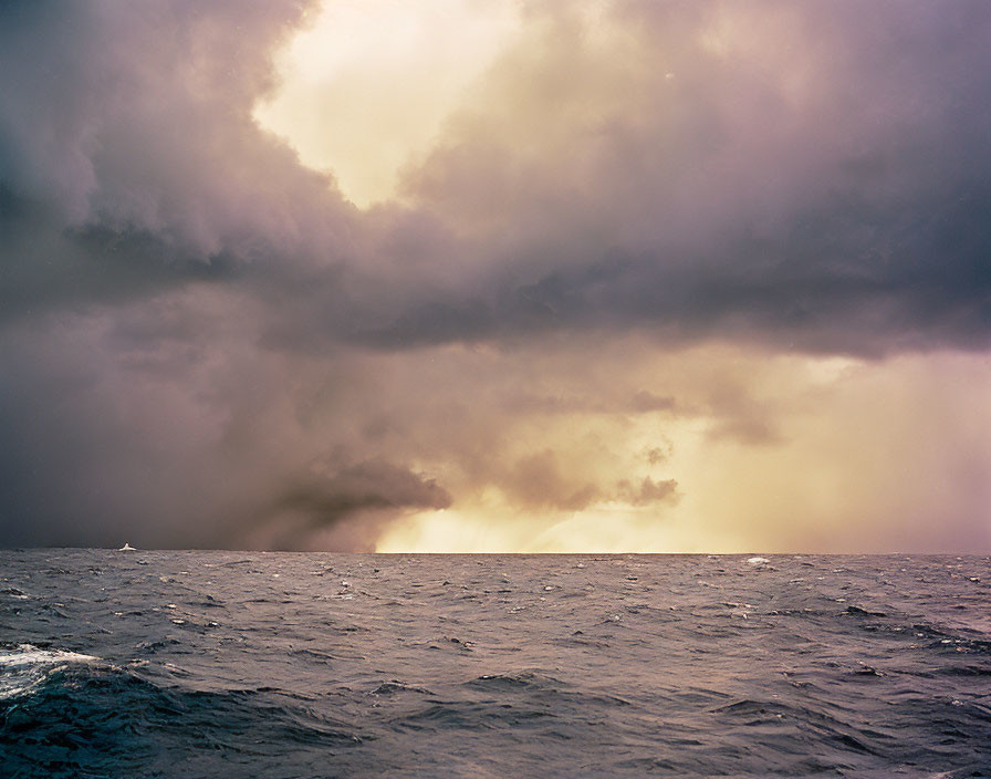 Dramatic ocean scene with storm clouds and sunlight glow