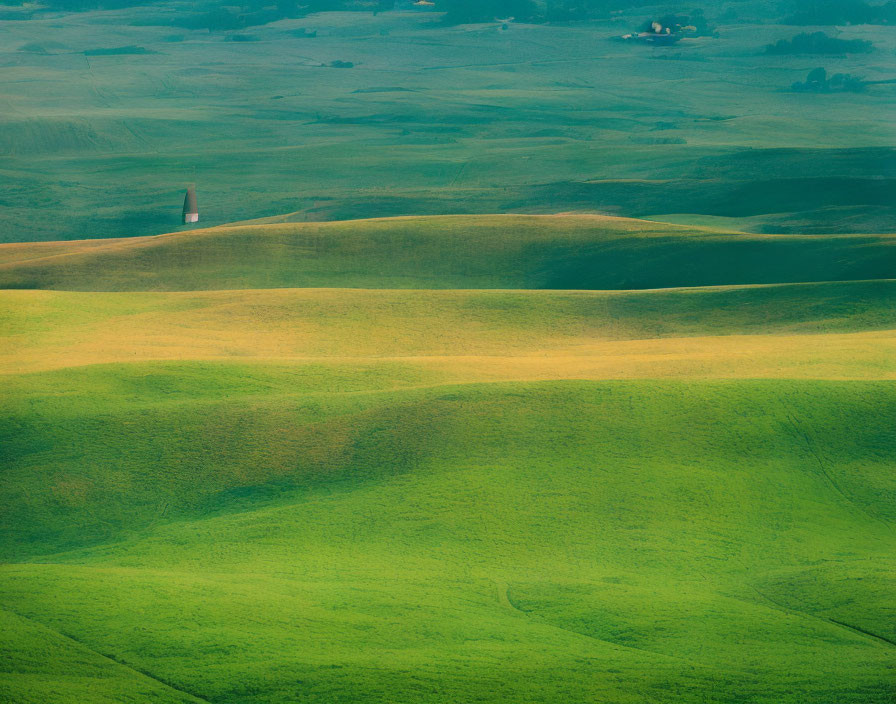 Vibrant green hills under hazy sky, with solitary tower.